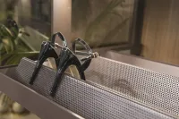 Elegant heeled sandals placed on the pull-out shoe rack