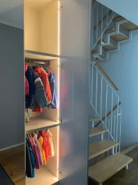 Schrank nach Maß: Dieser Garderobenschrank, der im Haus unseres Kunden in Königstein, Deutschland, installiert wurde, verbindet Funktionalität mit Stil. Mit einer Spiegeltür in der Mitte bietet er die perfekte Möglichkeit für einen schnellen Check, bevor man das Haus verlässt. Praktisch im Eingangsbereich positioniert, ist der Spiegel nahtlos als Teil des Schranks integriert und sorgt so für Platzersparnis und mühelose Funktionalität. Die anderen Türen sind matt lackiert in RAL 7001 mit integrierten Griffen vom Typ R, die in derselben Farbe wie die Türen ausgeführt sind. Der Innenraum verfügt über seitliche LED-Beleuchtung und Kleiderstangen in RAL 8019.

Die genauen Maße dieses Schranks sind 161 cm Breite, 262 cm Höhe und 61 cm Tiefe.