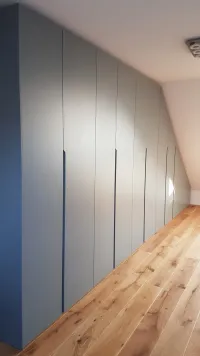Armoire sous pente: chaque toit a une inclinaison différente, c&rsquo;est pourquoi nous proposons notre configurateur, qui s&rsquo;adapte parfaitement à vos mesures pour créer un design d&rsquo;armoire pratique et fonctionnel, personnalisé selon vos besoins. Tout est soigneusement dissimulé derrière des portes aux couleurs personnalisées. Cette armoire est installée dans la maison de notre client à Herne, Allemagne - RAL7046 laqué mat avec poignées intégrées.

Les dimensions exactes de cette armoire sont 530 cm de largeur totale, une longueur de pente de toit de 208 cm, 240 cm de hauteur à gauche et 35 cm de hauteur à droite, et 61 cm de profondeur.
