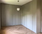 Custom-made corner built-in wardrobe: personalized color, dimensions, and designed by our client to fit perfectly in their bedroom – Düsseldorf, Germany – matte lacquered in RAL7044 with integrated handles. 

This wardrobe has varying depths to cover a chimney column and close it off with doors, creating a single, uniform surface.