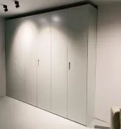 Armario a medida: Este armario fue instalado dentro de un nicho que es menos profundo que el armario en sí. Los paneles laterales permanecen visibles, por lo que han sido lacados. El pequeño tirador de uñero rectangular tirador S1 es del mismo color que el armario para un diseño uniforme. El color claro del armario combina perfectamente con el dormitorio de nuestro cliente en Múnich, Alemania – acabado lacado mate RAL 7035 con tirador S1 - tirador de uñero rectangular.

Las dimensiones exactas de este armario son: 277 cm de ancho, 265 cm de alto y 61 cm de profundidad.